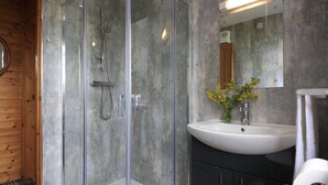 A modern bathroom with a glass-enclosed shower, a white sink, and a mirror above it. - Private Harry Potter themed lodge with lovely views (Arisaig)