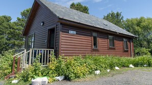 A log cabin with a wooden exterior, a porch with a railing, and a sign indicating it is a lodge. - Private Harry Potter themed lodge with lovely views (Arisaig)
