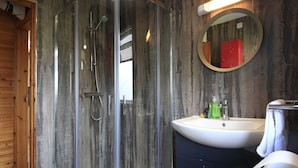 A modern bathroom with a glass-enclosed shower, a white sink, and a wooden vanity. - Private Star Wars themed lodge with lovely views (Arisaig)