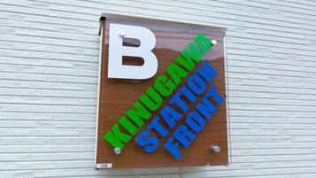 Et træskilt med bogstavet 'B' og tekst, der angiver 'Kindgawa Station Front'.