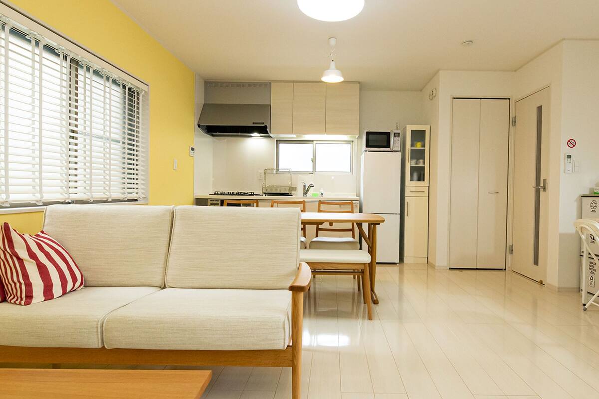 A compact living space with a sofa, dining table, and kitchen area.
