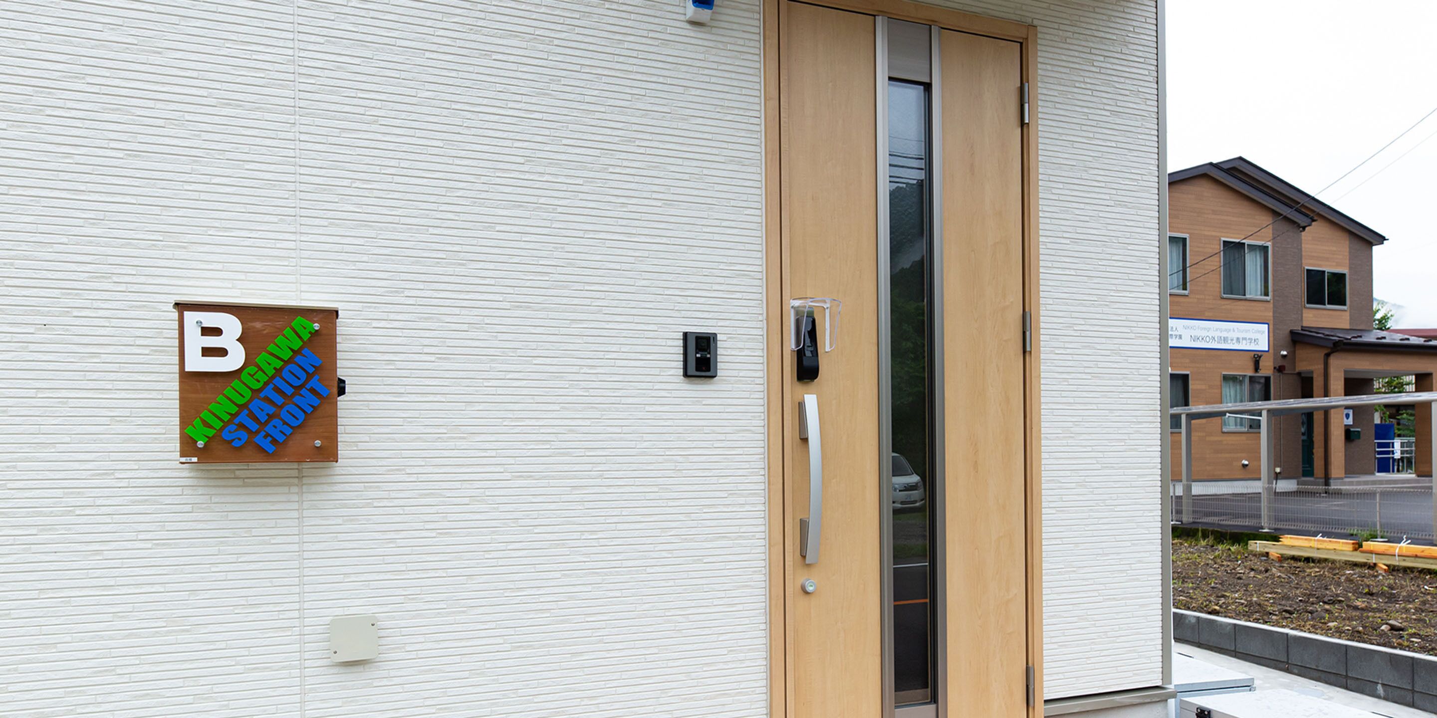 Een gebouw met een houten deur en een bord dat een stationsentree aangeeft.