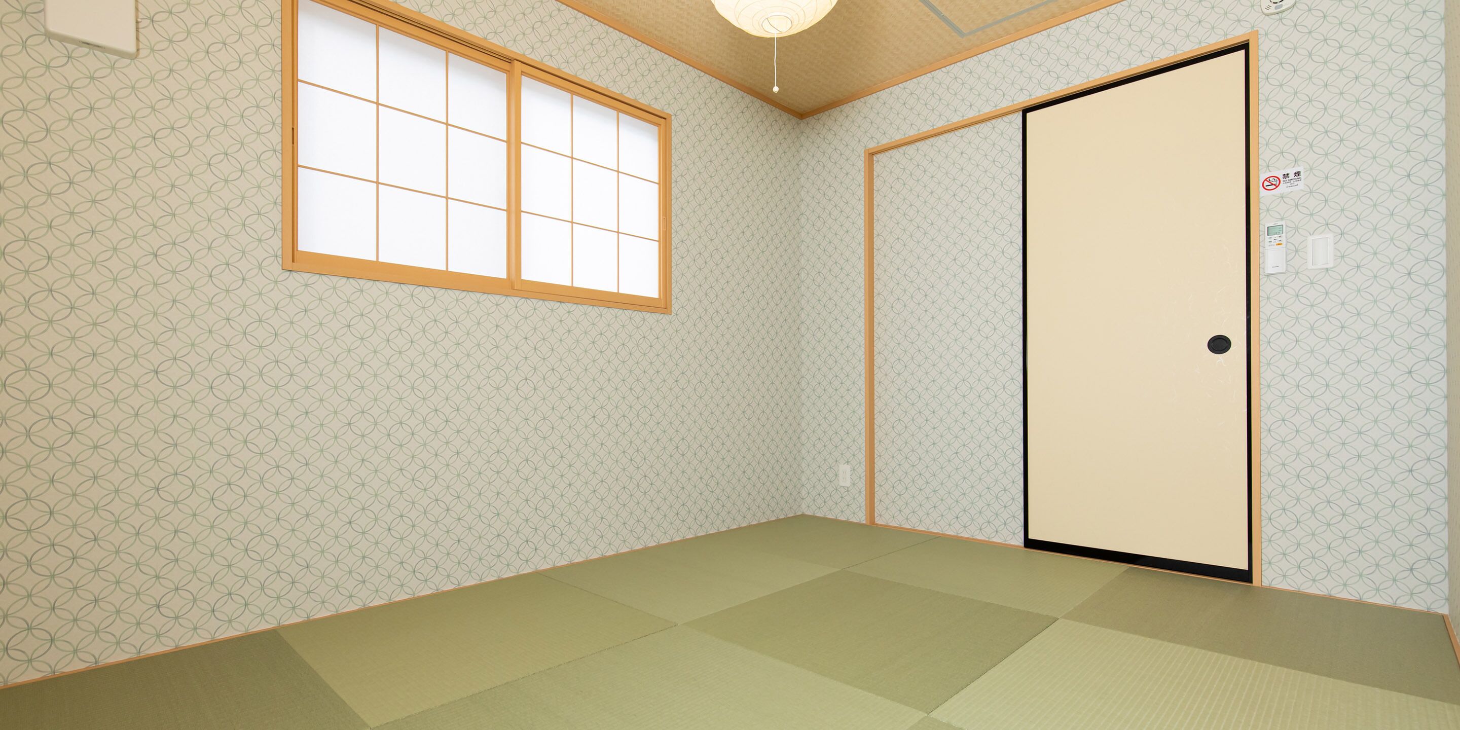 A room with tatami flooring, a shoji screen window, and a sliding door.