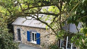 A stone cottage with a small porch, a blue door, and a window with blue shutters. - Charming house set in grounds and forest, guaranteed peace and quiet. (Gommenec'h)