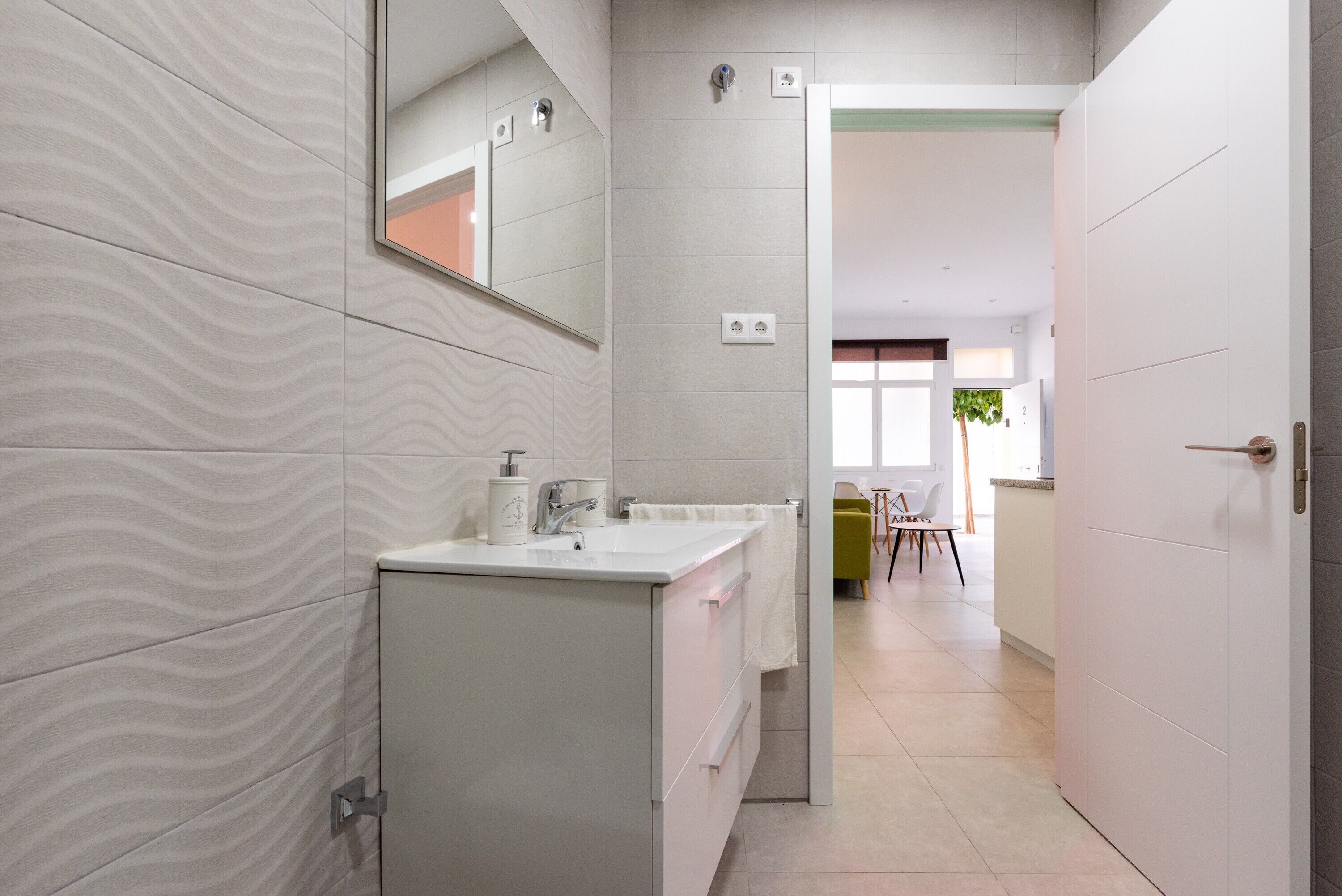 Ein modernes Badezimmer mit Waschbecken, Spiegel und Handtuchhalter.