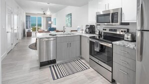 A modern kitchen with stainless steel appliances, a central island, and a view to the outside. - Oceana 201W See gorgeous sunsets! (Treasure Island)