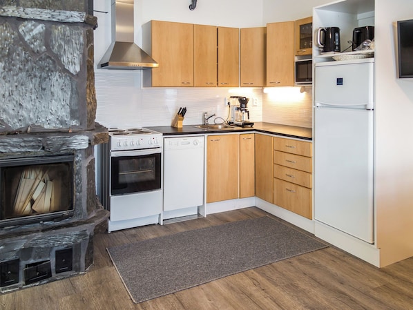 A modern kitchen with wooden cabinets, a built-in oven, a dishwasher, and a coffee maker.