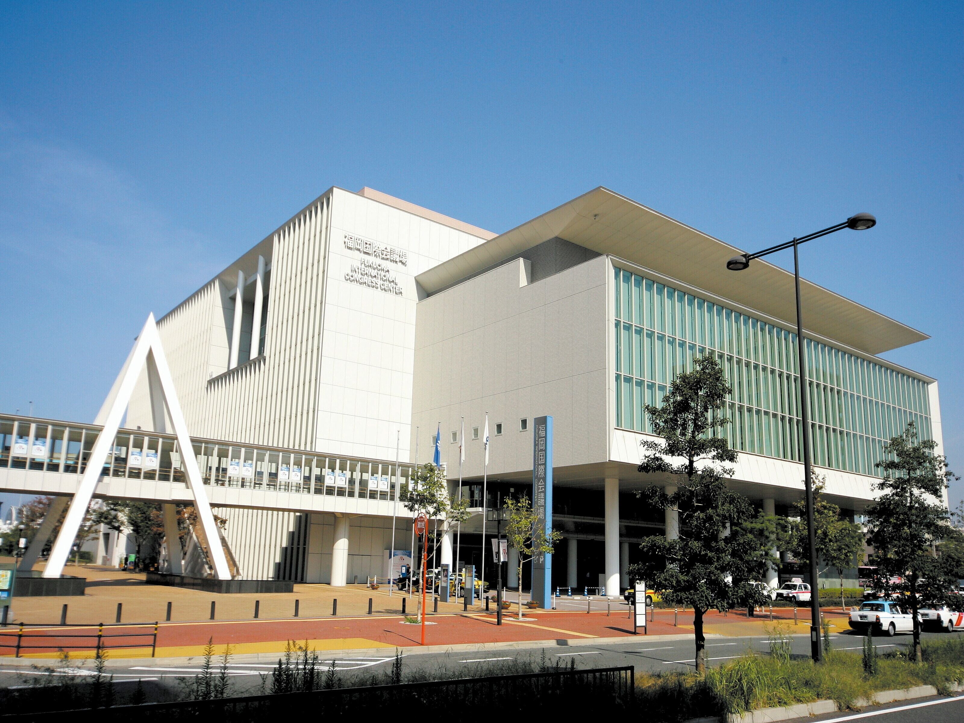 A modern building with a prominent entrance and a covered walkway.