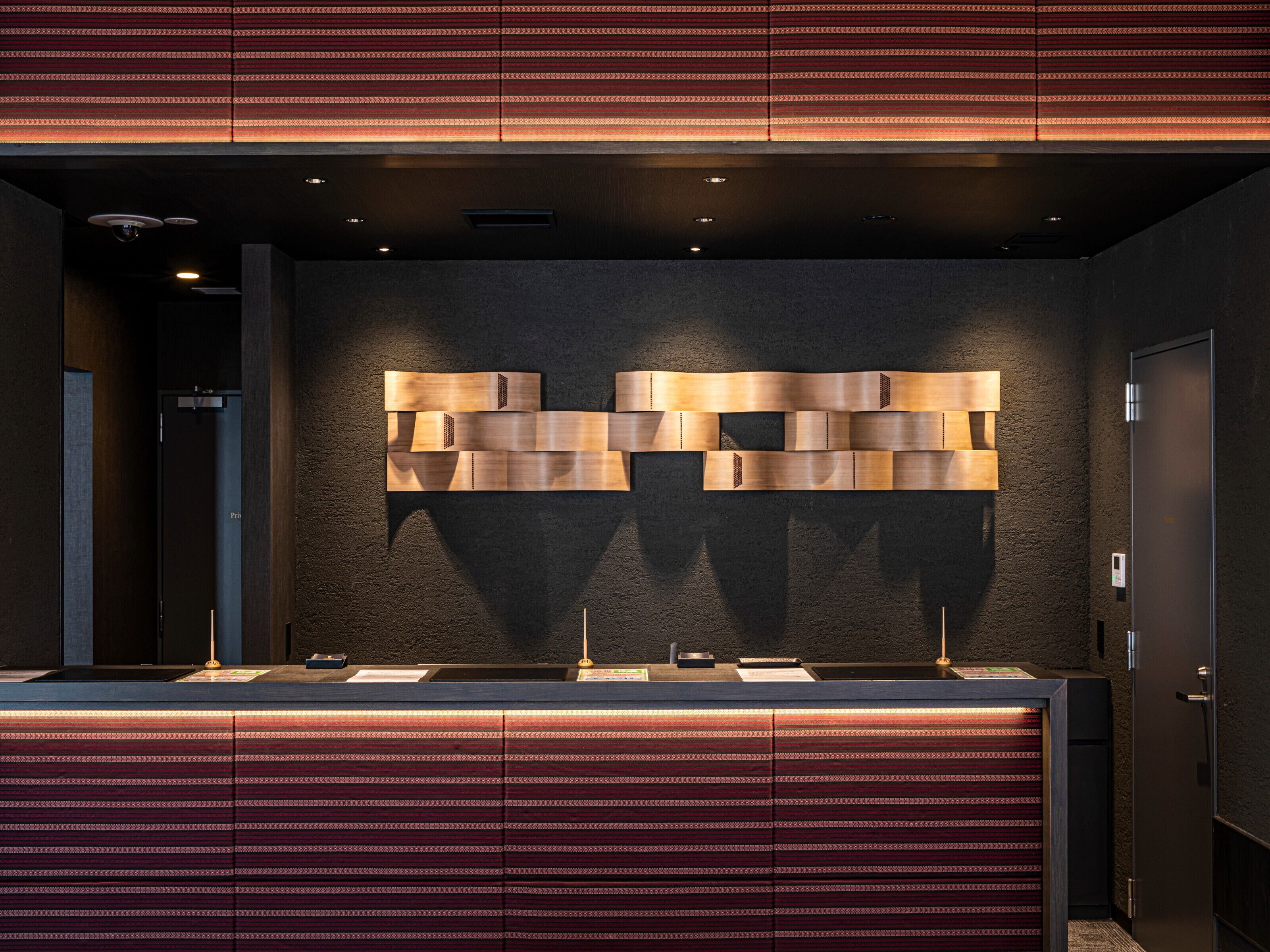 Een receptiebalie met een behangetje en een modern design.