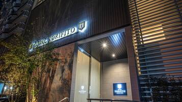 The exterior of Hotel Torifito with a modern facade, a visible entrance, and a sign indicating it is a hotel.