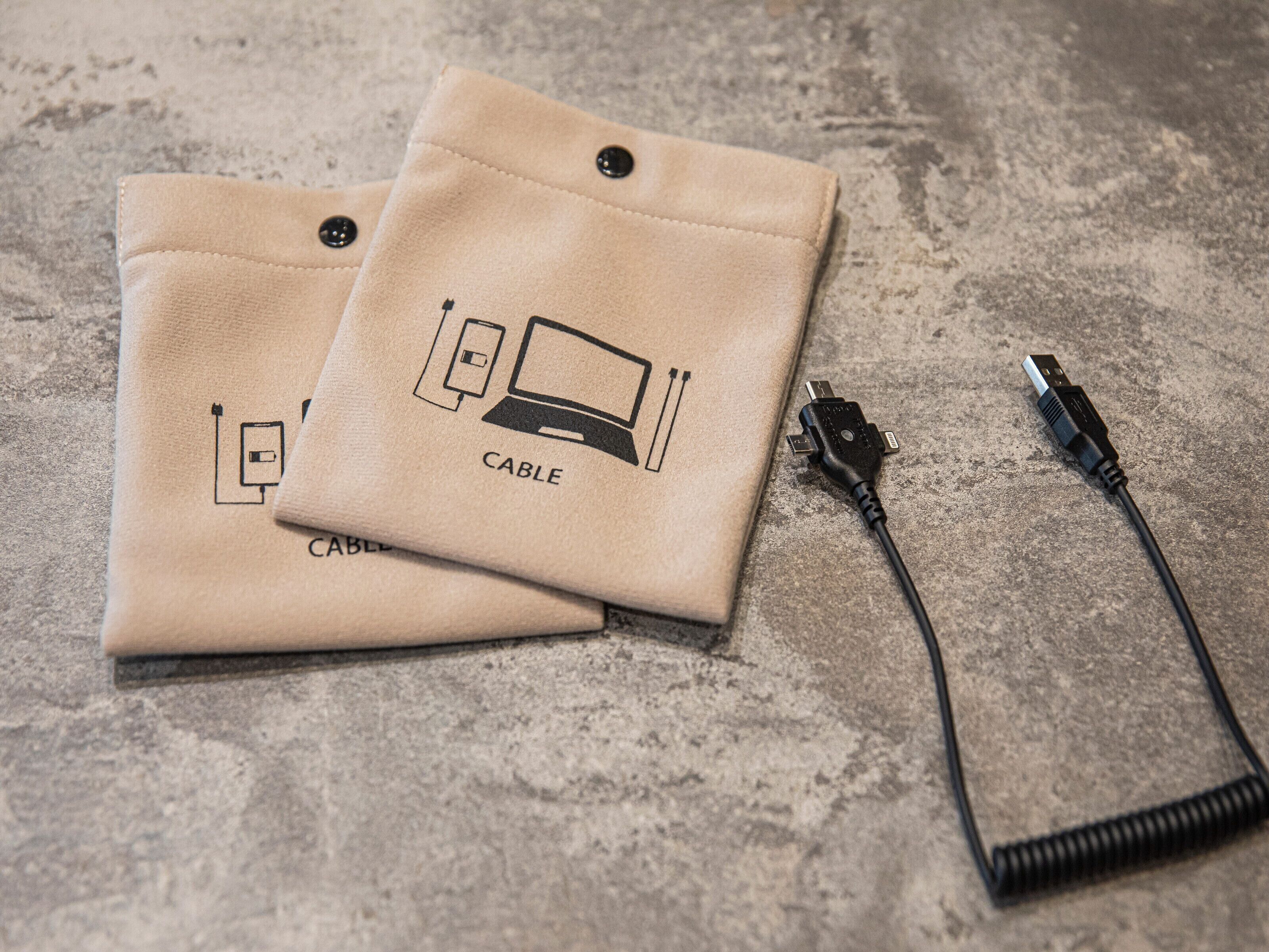 Two beige cable organizers with a cable plugged in.