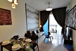 A modern living room with a dining area, a sofa, a coffee table, and a cityscape mural on the wall. - Forest City Ataraxia Park 1 by Wastone (Gelang Patah)