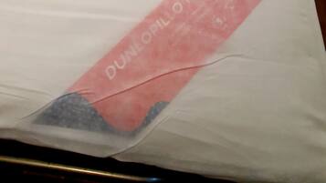 A bed with a white mattress and a red headboard.