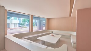 Uma sala de estar moderna com uma janela grande, um sofá branco e uma mesa de centro branca.