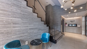 A modern interior with a staircase, a reception desk, and seating area. - Cheonan Brown Dot Hotel Cheonan Station (Cheonan)