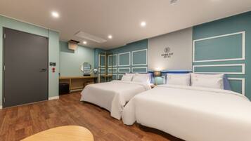 A hotel room with two beds, a desk, a mirror, and a wall-mounted sign.