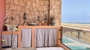 A balcony with a stone wall, a view of the beach, and a pool. - PORT DO SOL - free wifi NO LIMITS (Contea di Boa Vista)
