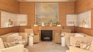 A luxurious lounge area with plush seating, a fireplace, and a large abstract painting on the wall. - The Woodward An Oetker Collection Hotel (Geneva)