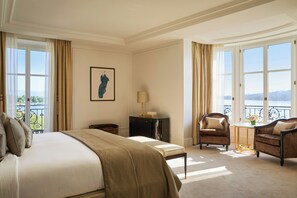 A hotel room with a large bed, two armchairs, a small table, and a view of the outdoors. - The Woodward An Oetker Collection Hotel (Geneva)