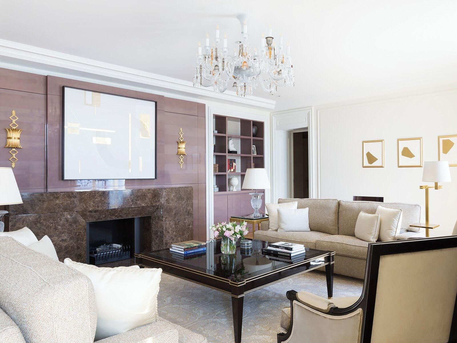 Uma sala de estar moderna com lareira, um sofá, uma mesa de centro e um candelabro.