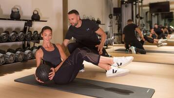 Uma academia com equipamentos de ginástica, incluindo kettlebells e halteres.