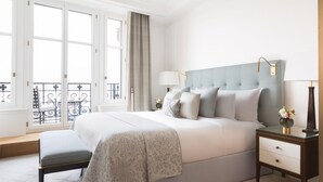 A bedroom with a large bed, bedside tables, a bench, and a view of the outside balcony. - The Woodward An Oetker Collection Hotel (Geneva)