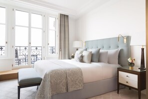 A bedroom with a large bed, bedside tables, a bench, and a view of the outside balcony. - The Woodward An Oetker Collection Hotel (Geneva)