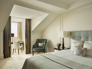 A hotel room with a large bed, a desk, a chair, and a lamp. - The Woodward An Oetker Collection Hotel (Geneva)