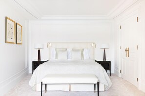 A spacious bedroom with a large bed, two bedside tables, and a bench. - The Woodward An Oetker Collection Hotel (Geneva)