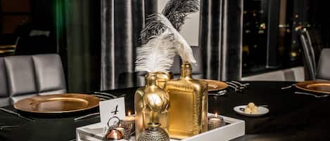 A table set for a meal with gold and white tableware, a feather, and decorative items.