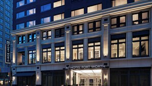 A modern hotel facade with large windows and a prominent entrance.