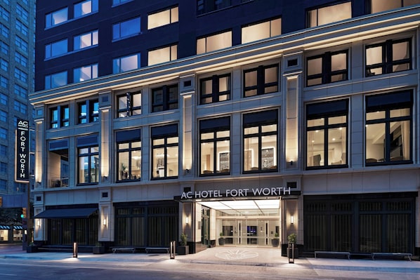 A modern hotel facade with large windows and a prominent entrance.