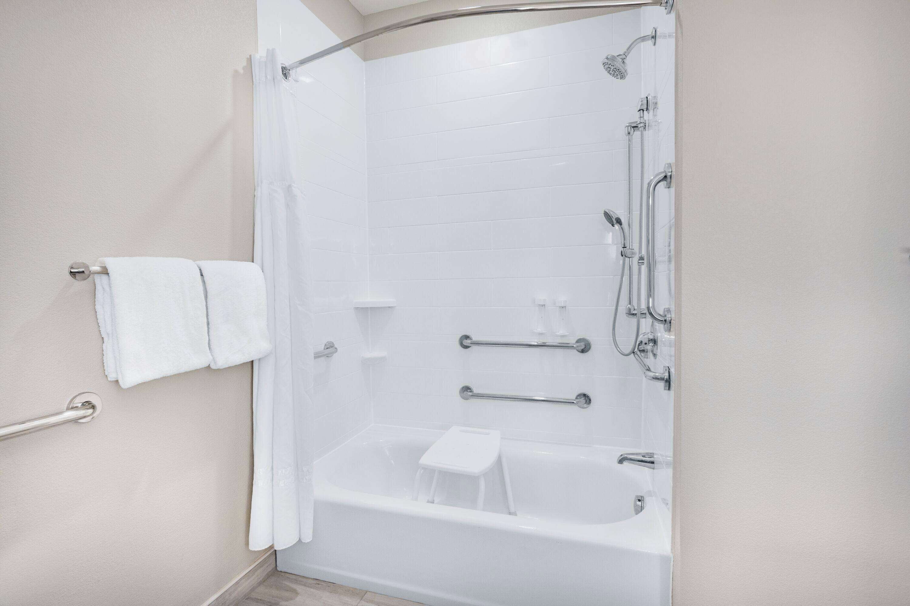 Un baño moderno con ducha a nivel, bañera y retrete.