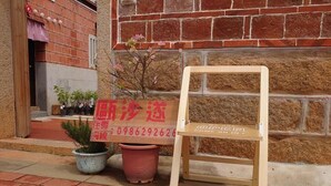 A wooden chair and a sign with contact information in front of a brick building. - O! Share Sweet B&B II (Jinning)
