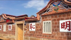 A traditional building with brick walls and decorative elements, including a wooden door and a window with vertical bars. - O! Share Sweet B&B II (Jinning)