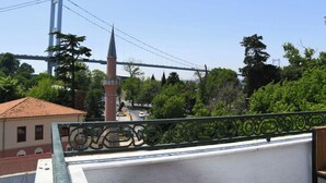 A view of a bridge, a tower, and a building with a tiled roof.