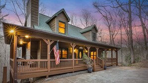 A wooden cabin with a porch, a flag, and a sign that reads 'CARN'. - Tie One On The River | Ellijay, GA (Ellijay)