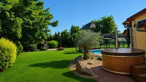 A well-maintained garden with a hot tub, a swimming pool, and a house with a modern design. - Rural Cottage, indoor swinming pool and spa, playg (Ostheim)