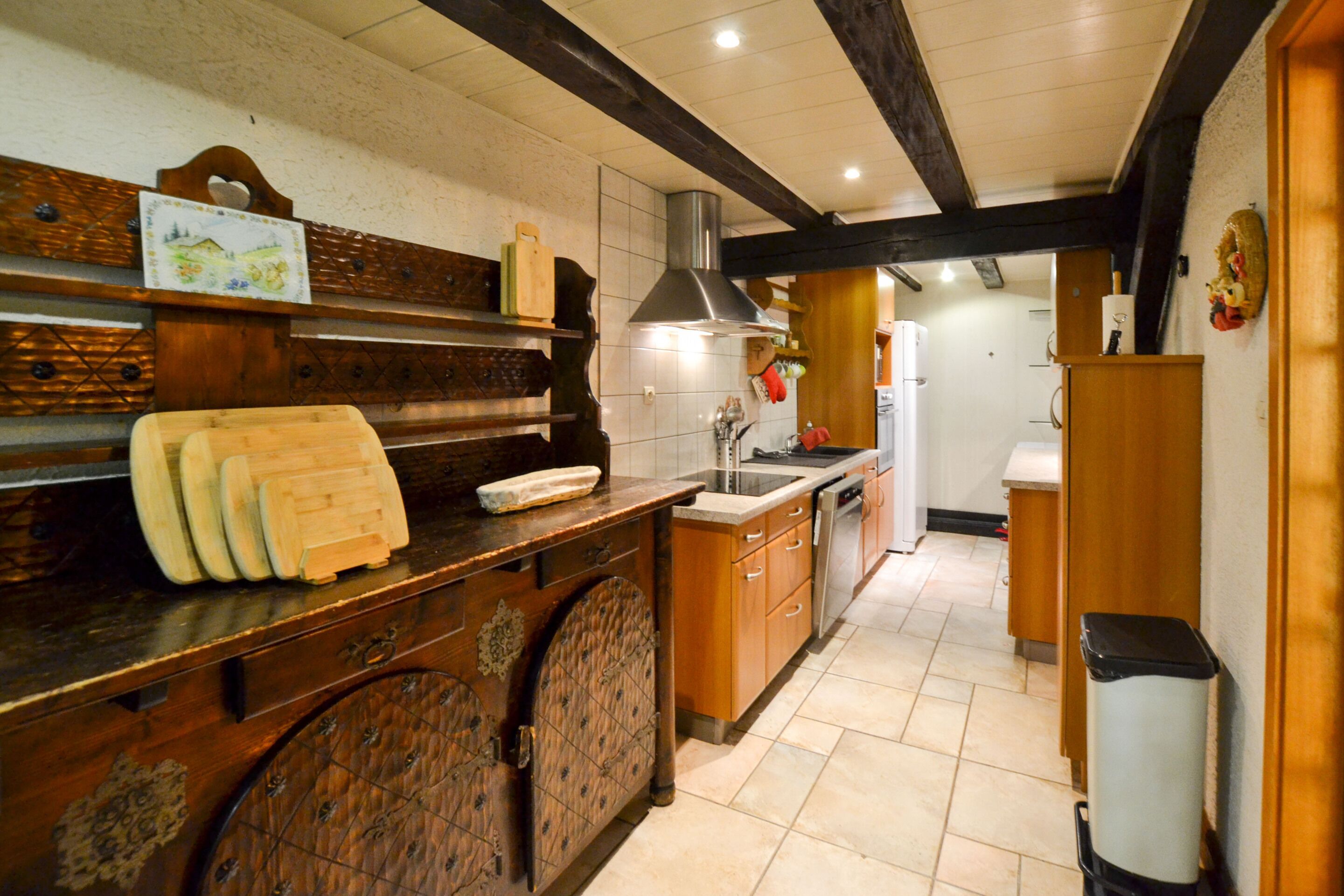 Una cocina con armarios de madera, una encimera con tabla de cortar y un fregadero.
