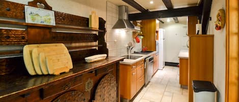 Una cocina con armarios de madera, una encimera con tabla de cortar y un fregadero.