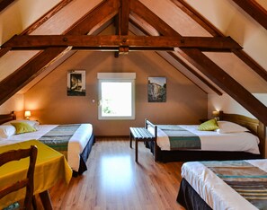 A room with two beds, a table, and a window.