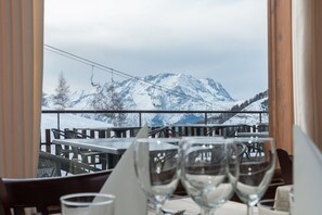 En restaurang med utsikt över bergen, med bord och stolar.