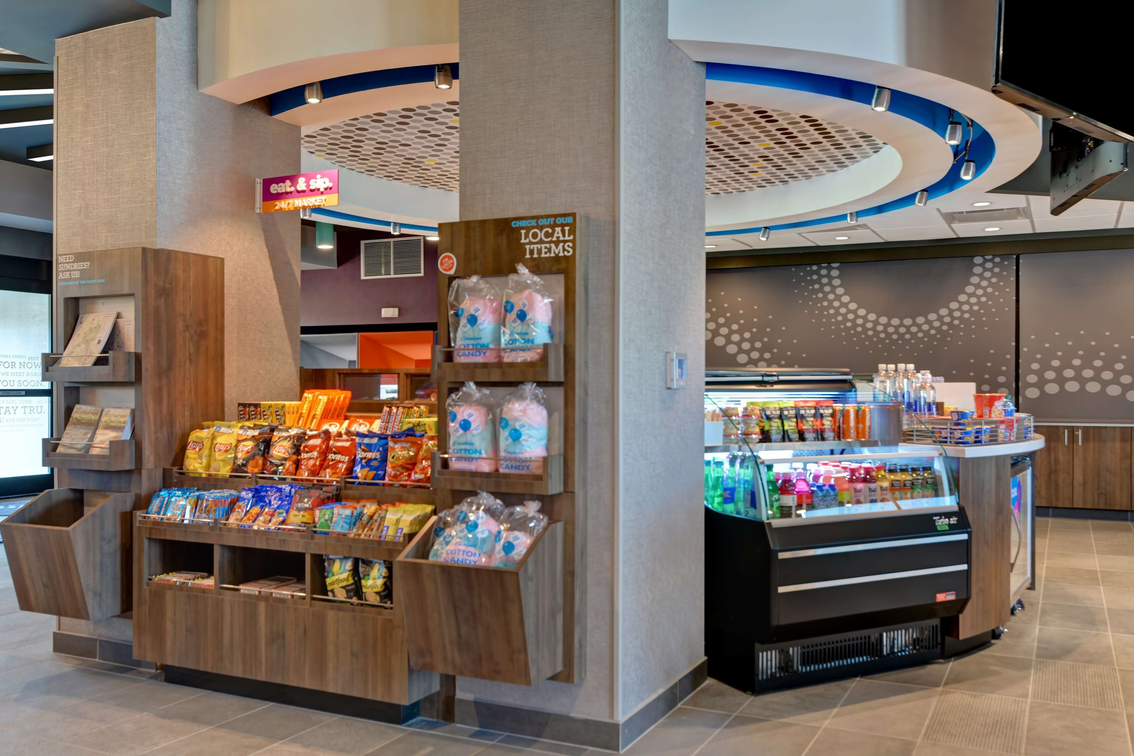 A snack kiosk with a variety of packaged snacks and cotton candy.