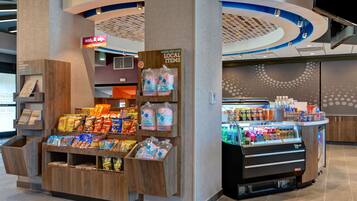 A snack kiosk with a variety of packaged snacks and cotton candy.