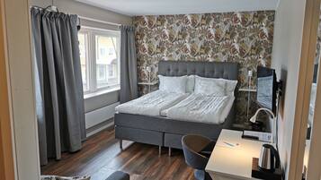 Ein modernes Schlafzimmer mit einem großen Bett, einem Schreibtisch und einem Stuhl.
