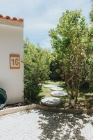 Un sendero pavimentado con piedras que conducen a una pared blanca con un cartel con el número 10.