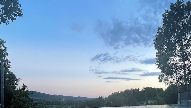 Ein klarer Blick auf einen Infinity-Pool mit Ausblick auf die umliegende Landschaft und Bäume.
