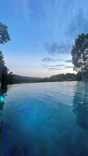 A clear view of an infinity pool with a view of the surrounding landscape and trees.