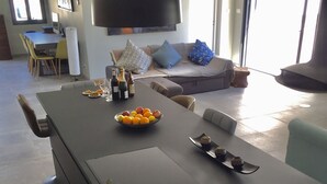 Eine moderne Küche mit einer großen Kochinsel, einem Essbereich mit Stühlen und einer Couch.