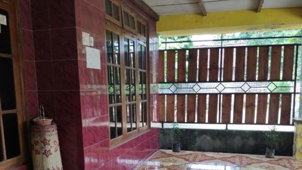 A room with a tiled floor, a wooden door, and a window with a metal grill.